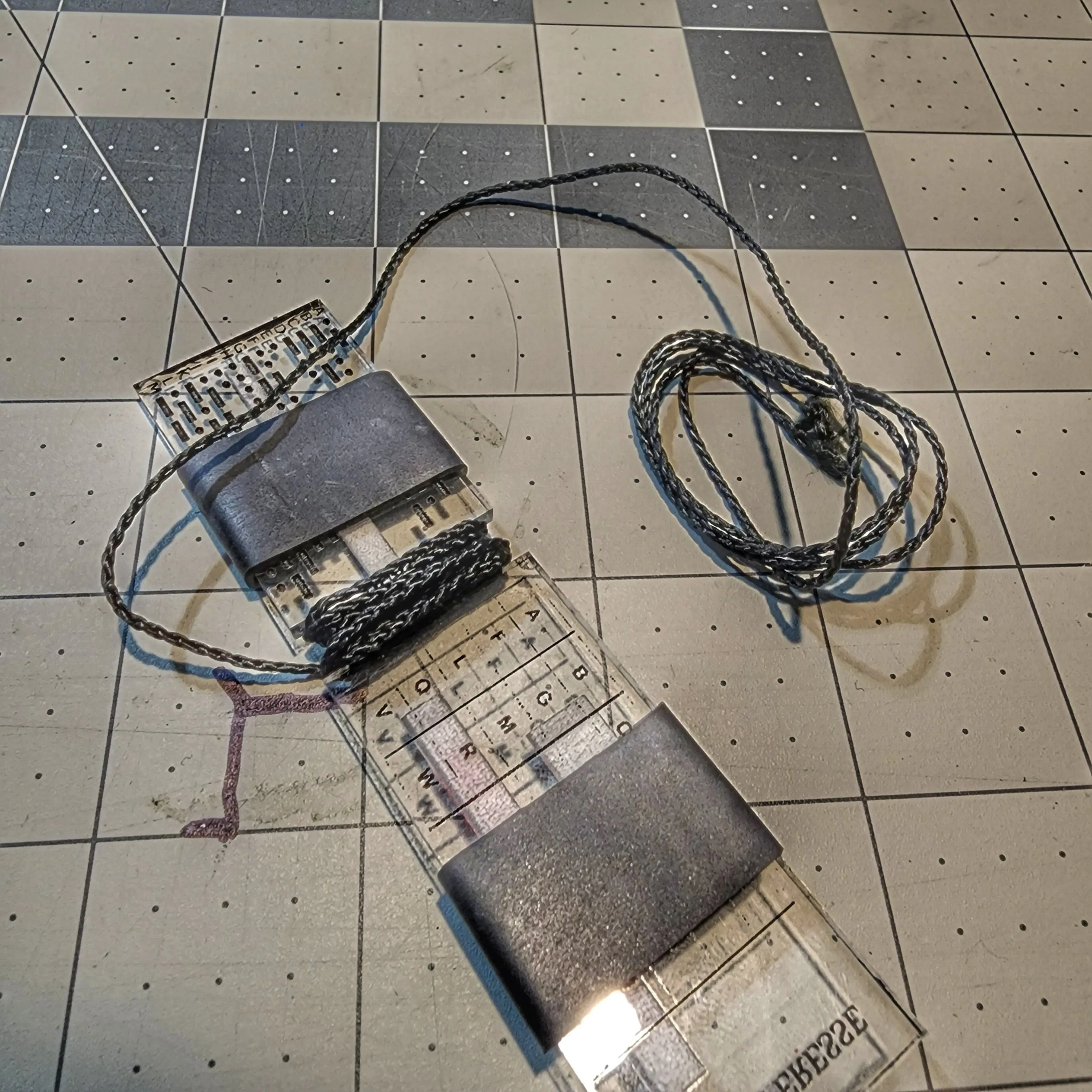 Partitioned Kit & Reference - Bar (PKR Bar): Keychain with compartmentalized storage areas for supplies and quick reference data engraved on backing.